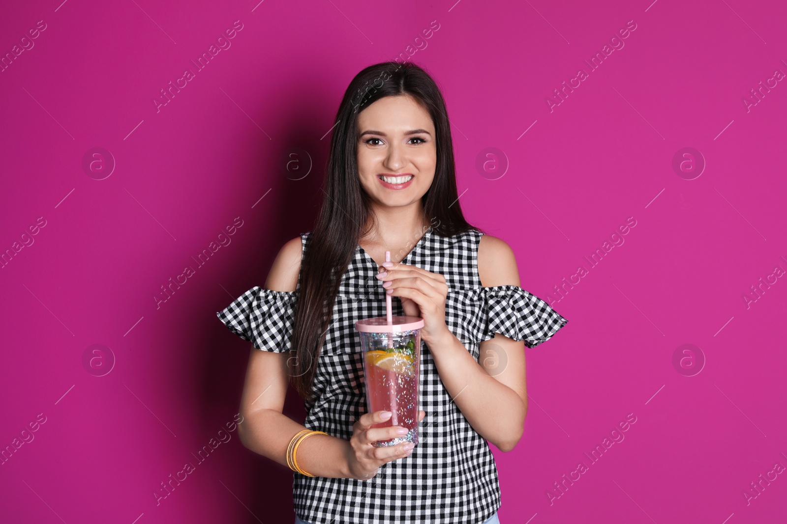 Photo of Young woman with tasty lemonade on color background. Natural detox drink