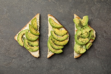 Photo of Tasty avocado toasts on grey table, flat lay