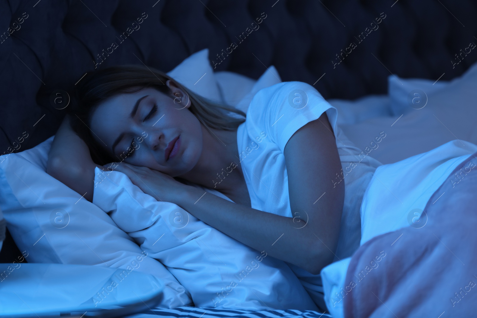 Photo of Young woman sleeping in bed at night. Sleeping time