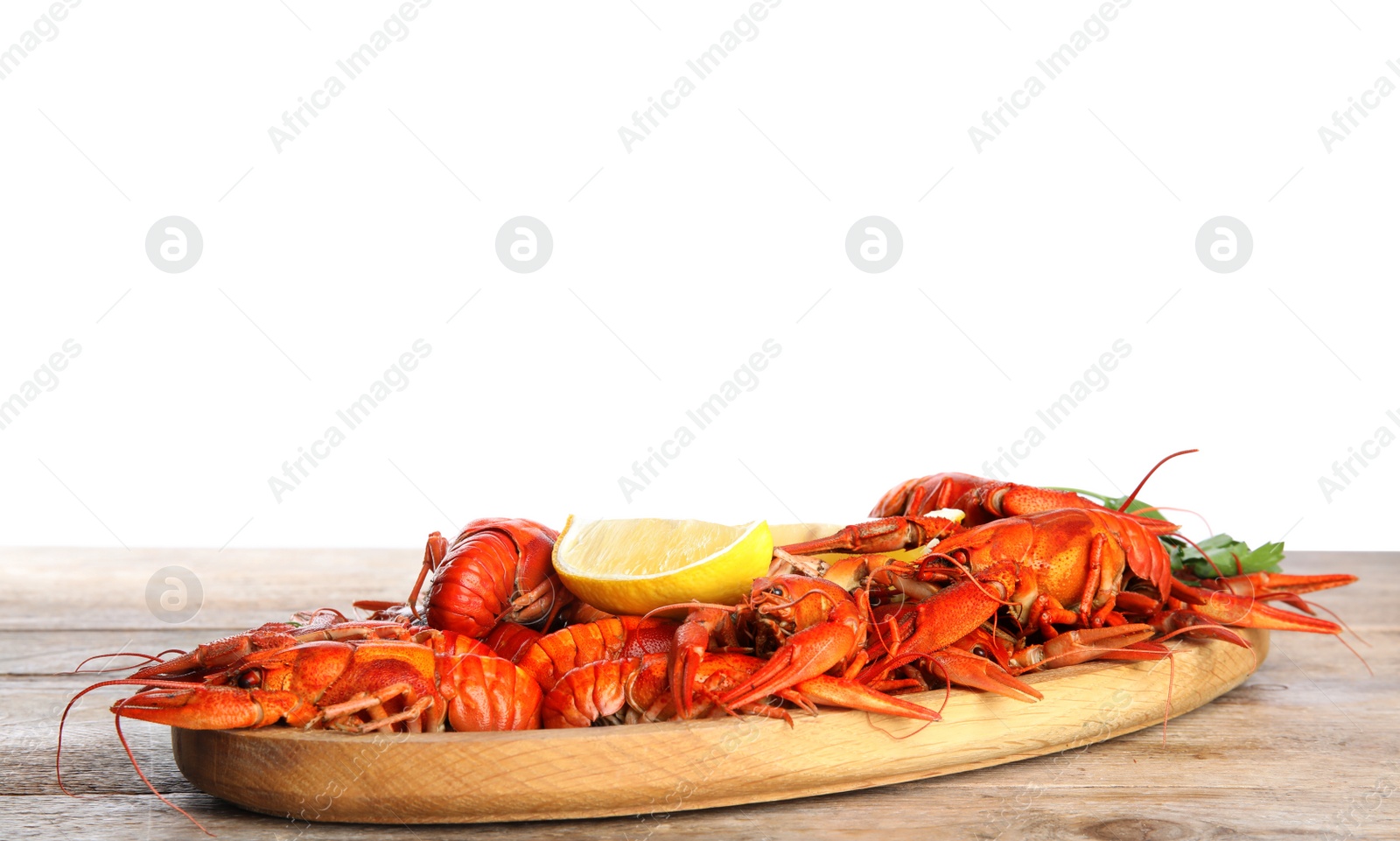 Photo of Delicious boiled crayfishes on wooden table against white background