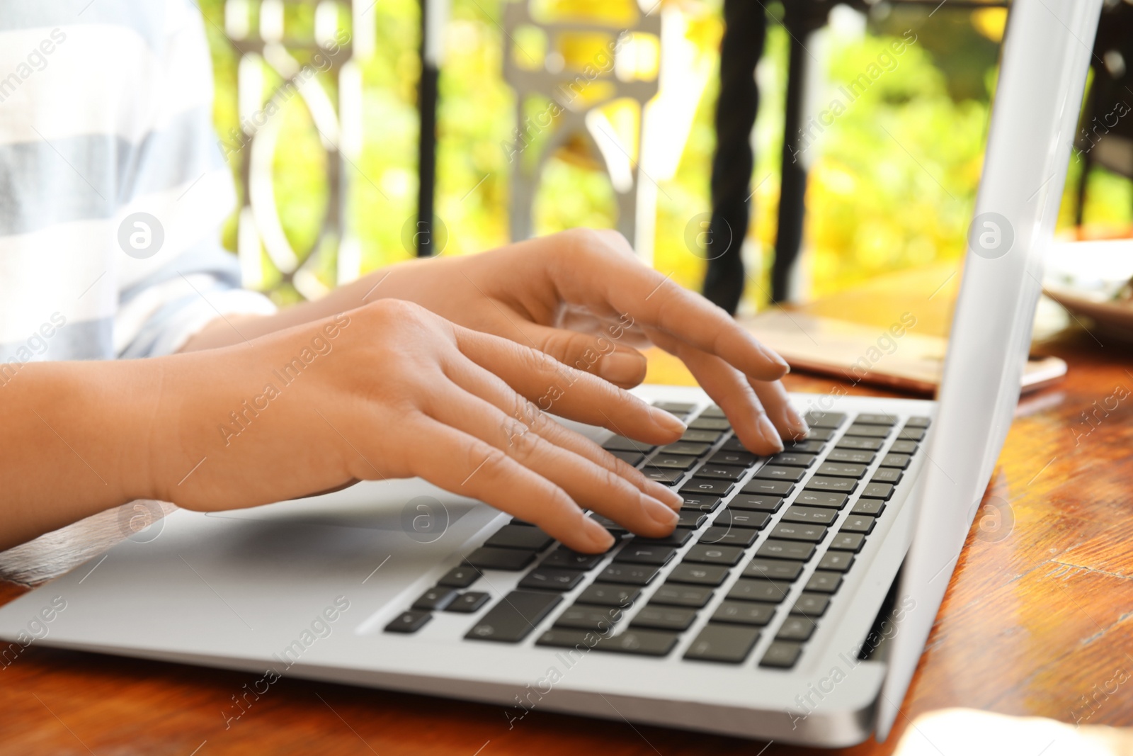 Photo of Woman using laptop in cafe, closeup. Blogger at work