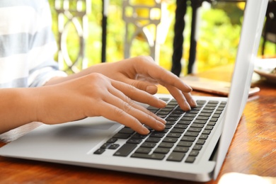 Photo of Woman using laptop in cafe, closeup. Blogger at work