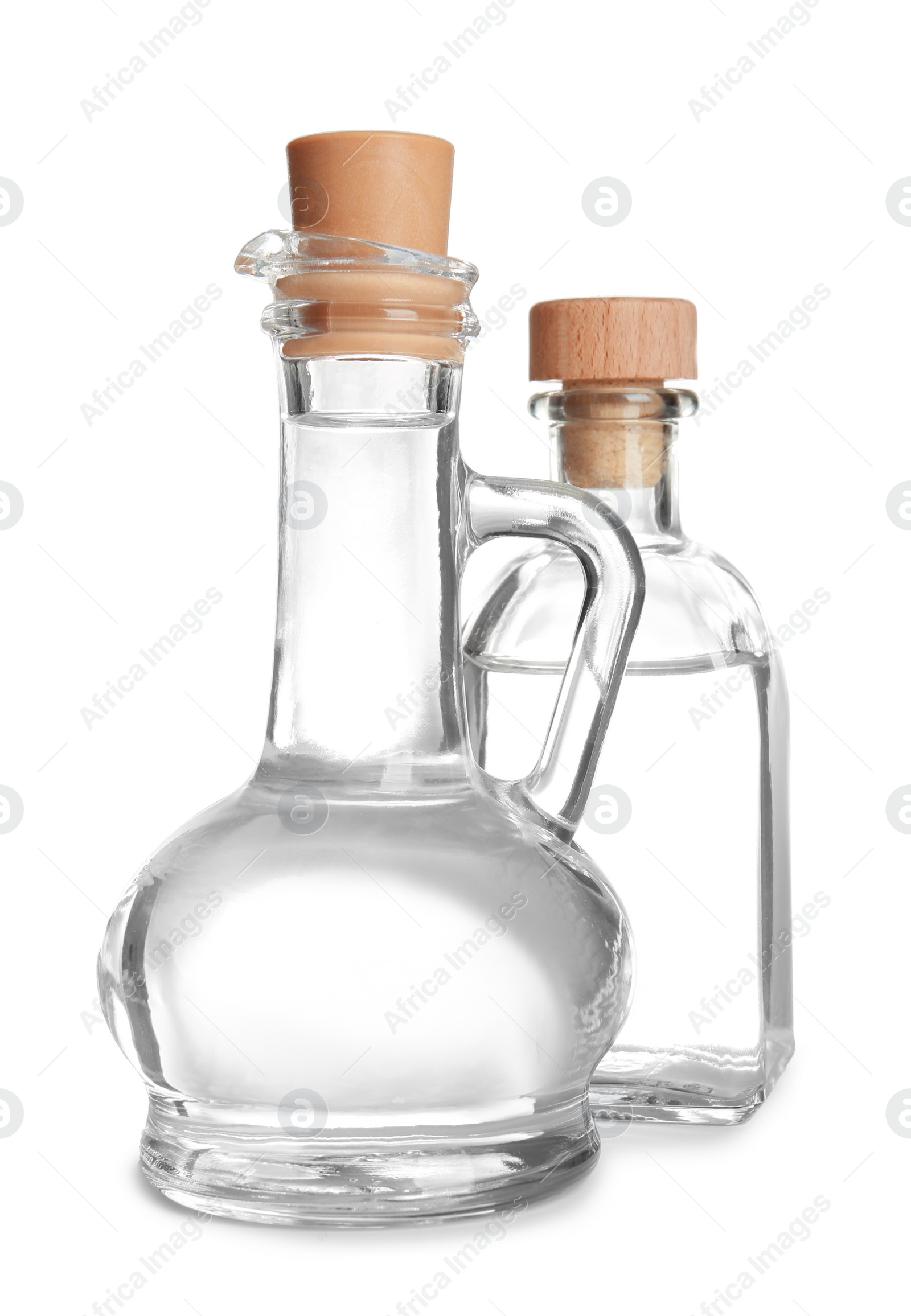 Photo of Glass jug and bottle with vinegar on white background