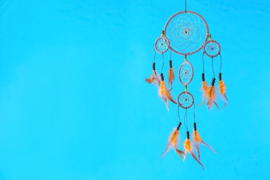 Photo of Beautiful handmade dream catcher on light blue background. Space for text