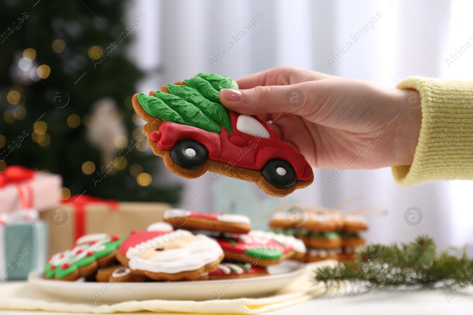 Photo of Woman with decorated Christmas cookie at table, closeup