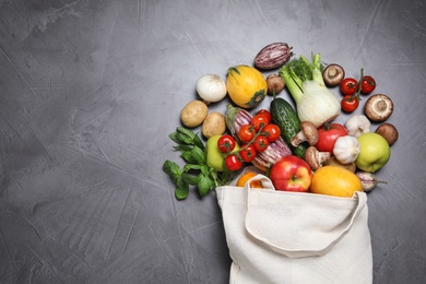 Photo of Bag with fresh vegetables and apples on dark background, flat lay. Space for text