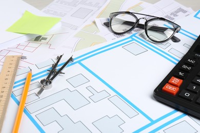 Photo of Office stationery and eyeglasses on cadastral maps of territory with buildings