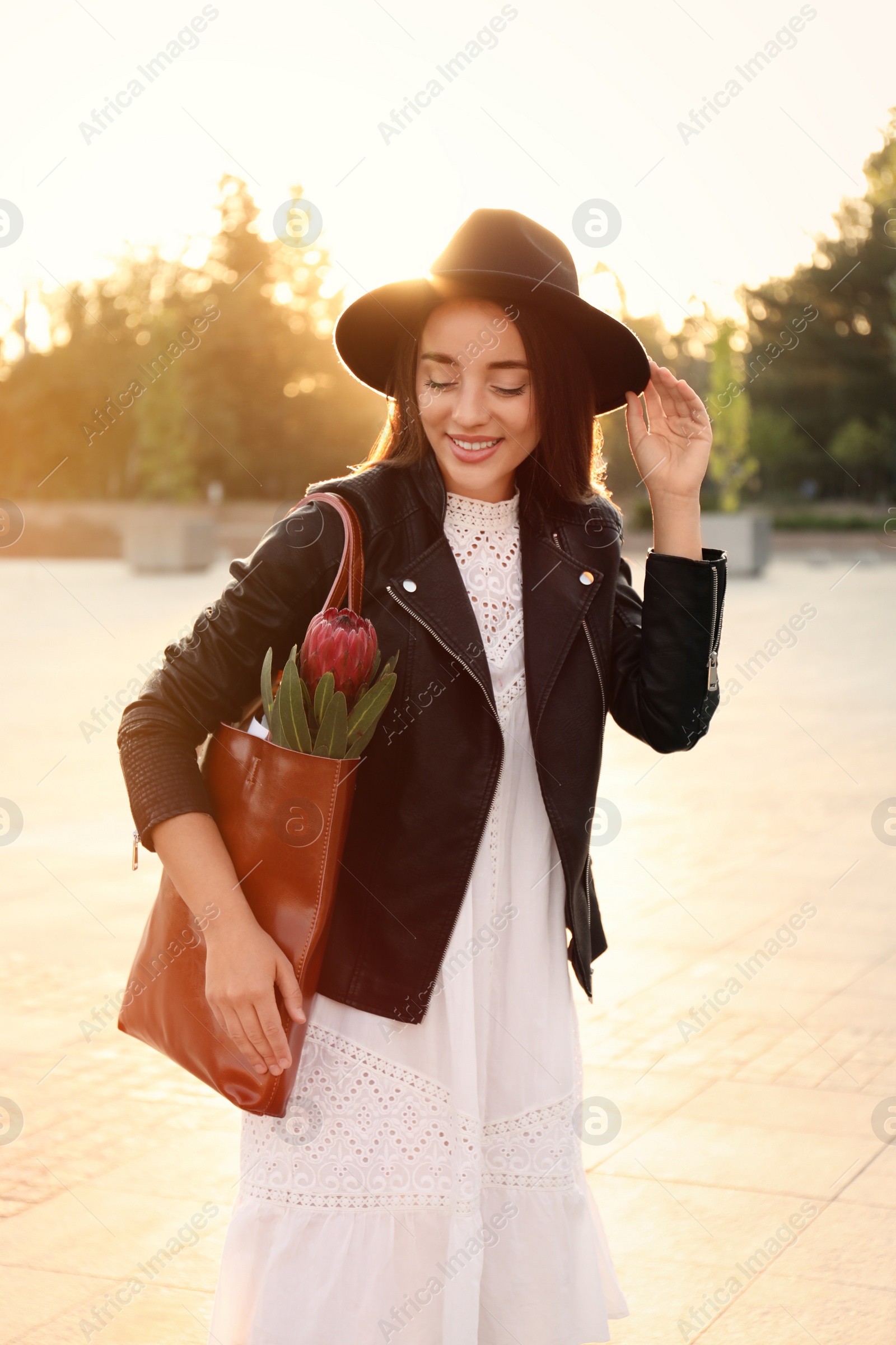 Photo of Young woman with leather shopper bag on city street