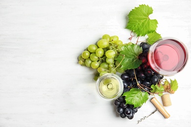 Photo of Flat lay composition with fresh ripe juicy grapes and space for text on wooden background
