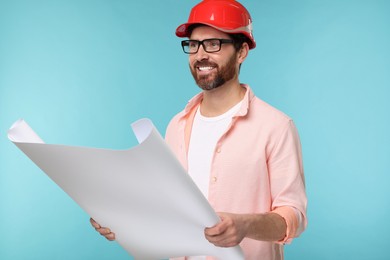 Photo of Architect in hard hat with draft on light blue background