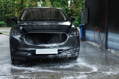 Photo of Washing auto with high pressure water jet at outdoor car wash