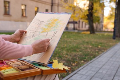 Photo of Woman drawing with soft pastels on street, closeup