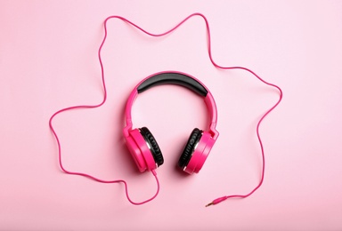 Photo of Stylish headphones on color background, top view