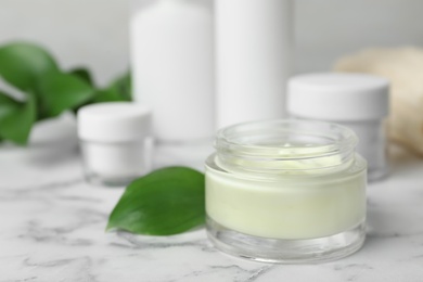 Photo of Jar of body care product on marble table. Space for text