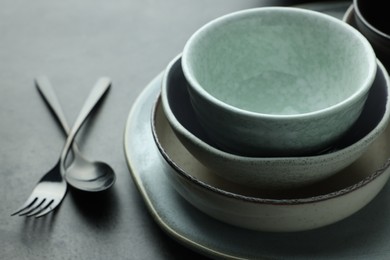 Photo of Stylish empty dishware and cutlery on grey table, closeup