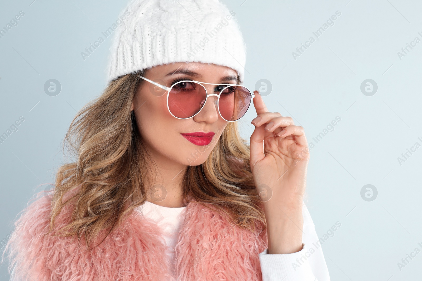 Photo of Young woman wearing stylish sunglasses on light grey background