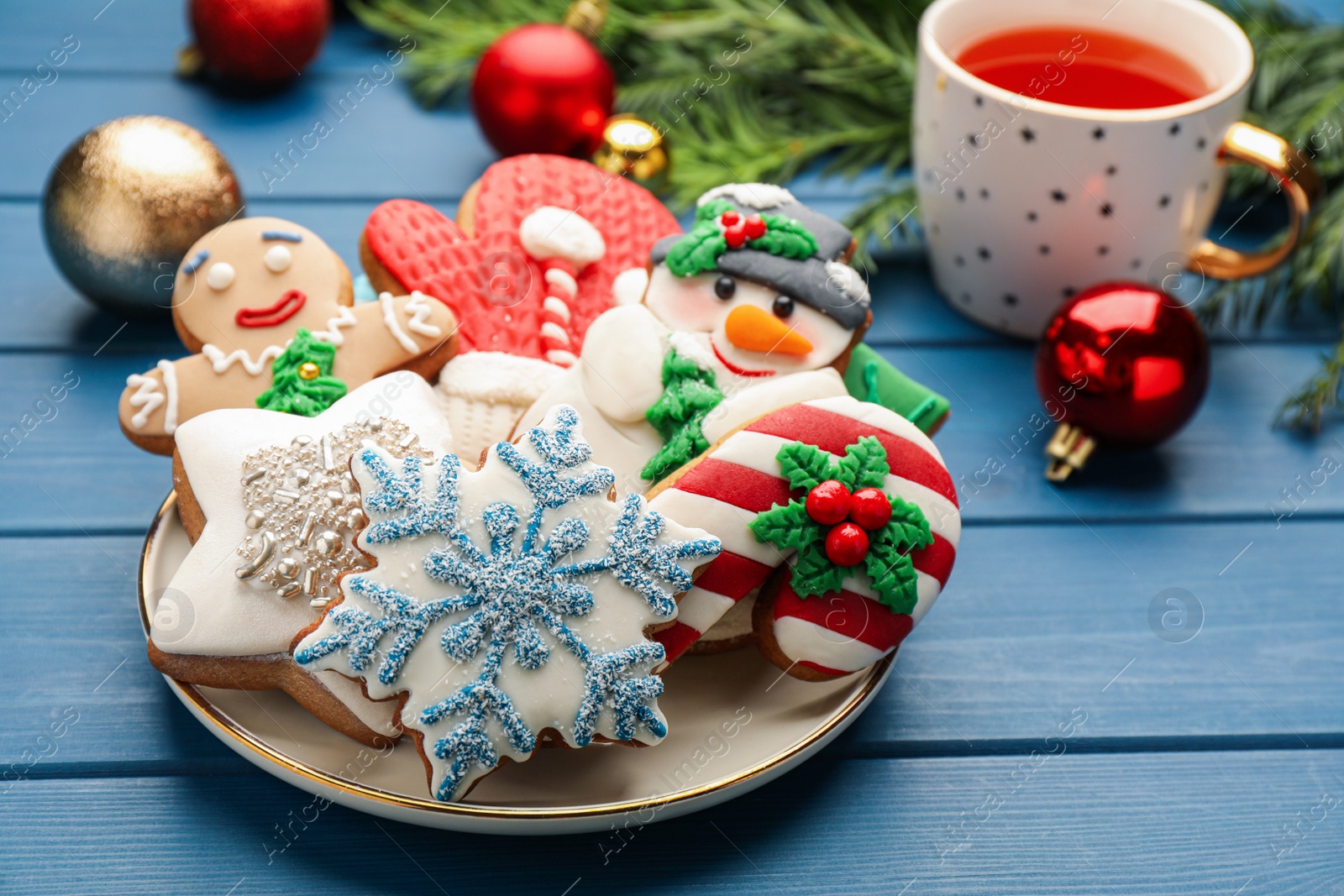 Photo of Delicious homemade Christmas cookies and festive decor on blue wooden table