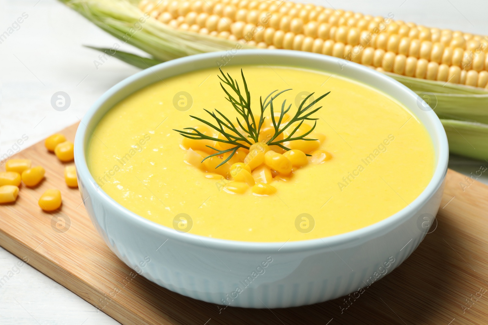 Photo of Delicious creamy corn soup on white table