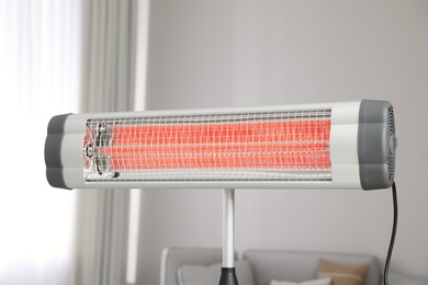 Photo of Modern electric infrared heater in living room