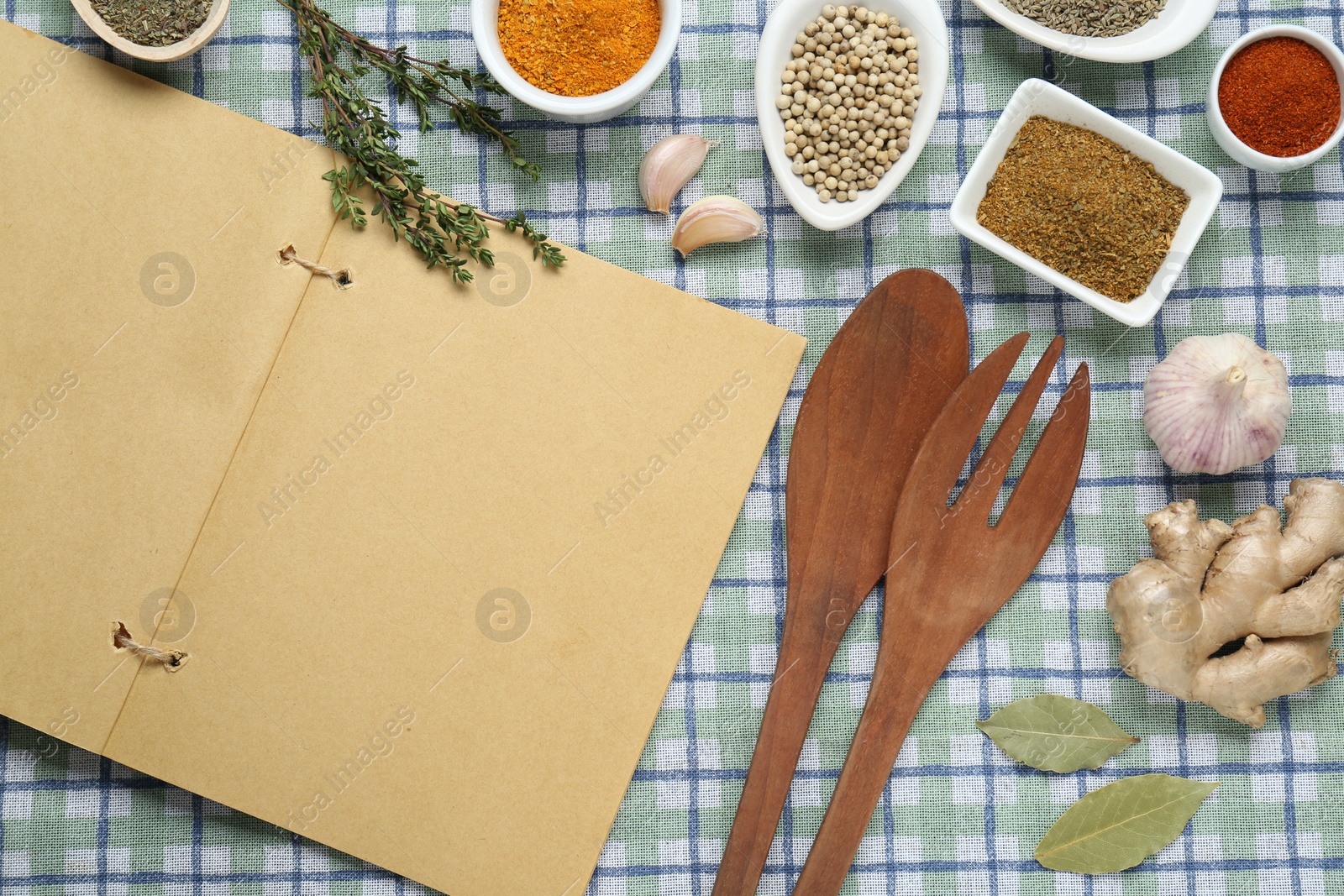 Photo of Blank recipe book and different ingredients on checkered tablecloth, flat lay. Space for text