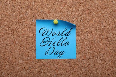 Paper note with phrase World Hello Day pinned to cork board