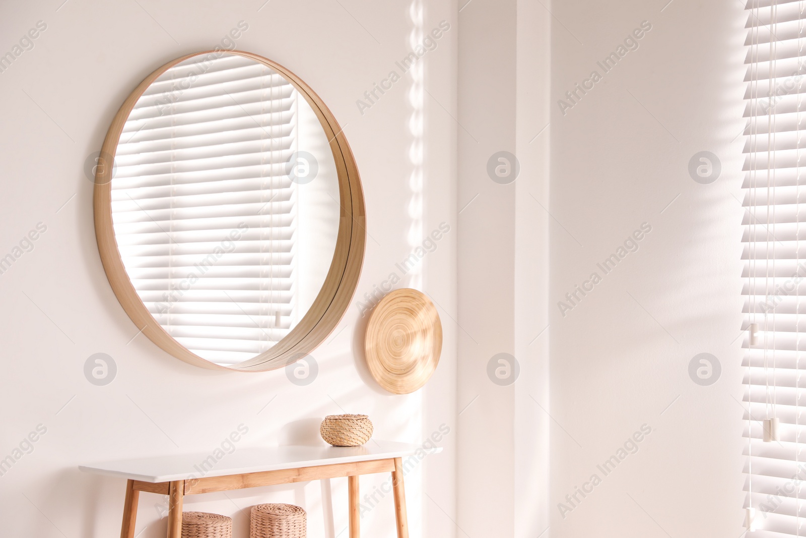 Photo of Stylish round mirror hanging on white wall in room