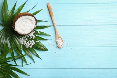 Composition with fresh coconut flakes on color wooden background, top view