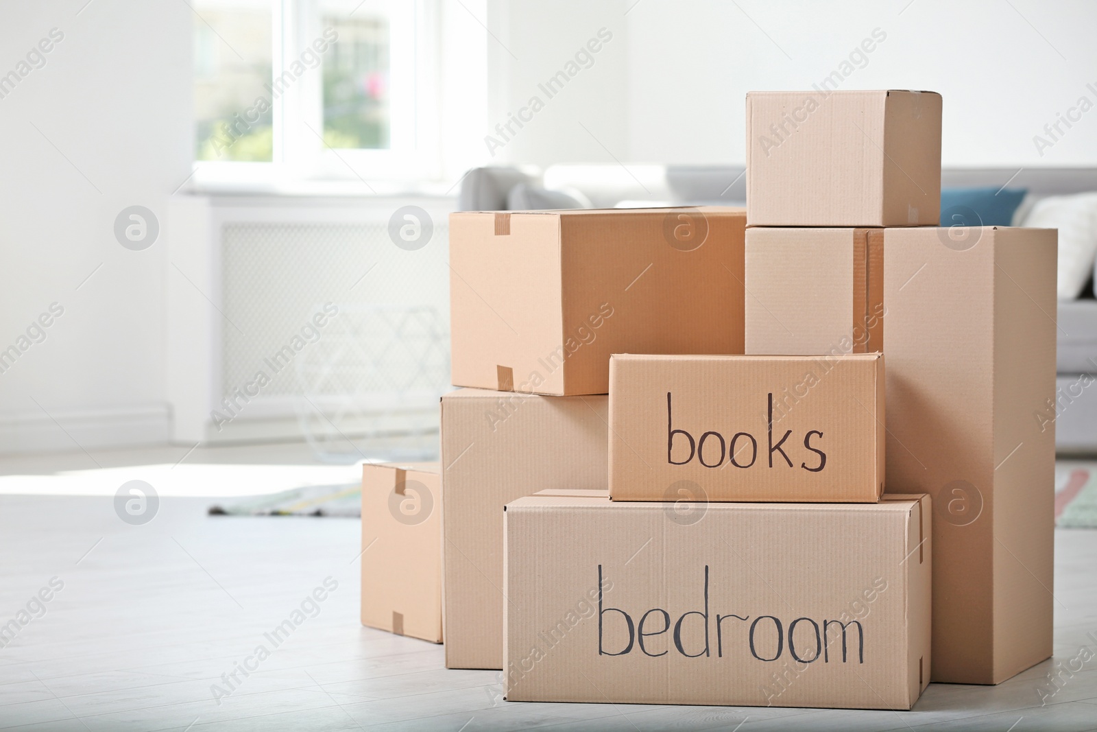 Photo of Pile of cardboard boxes indoors. Moving day