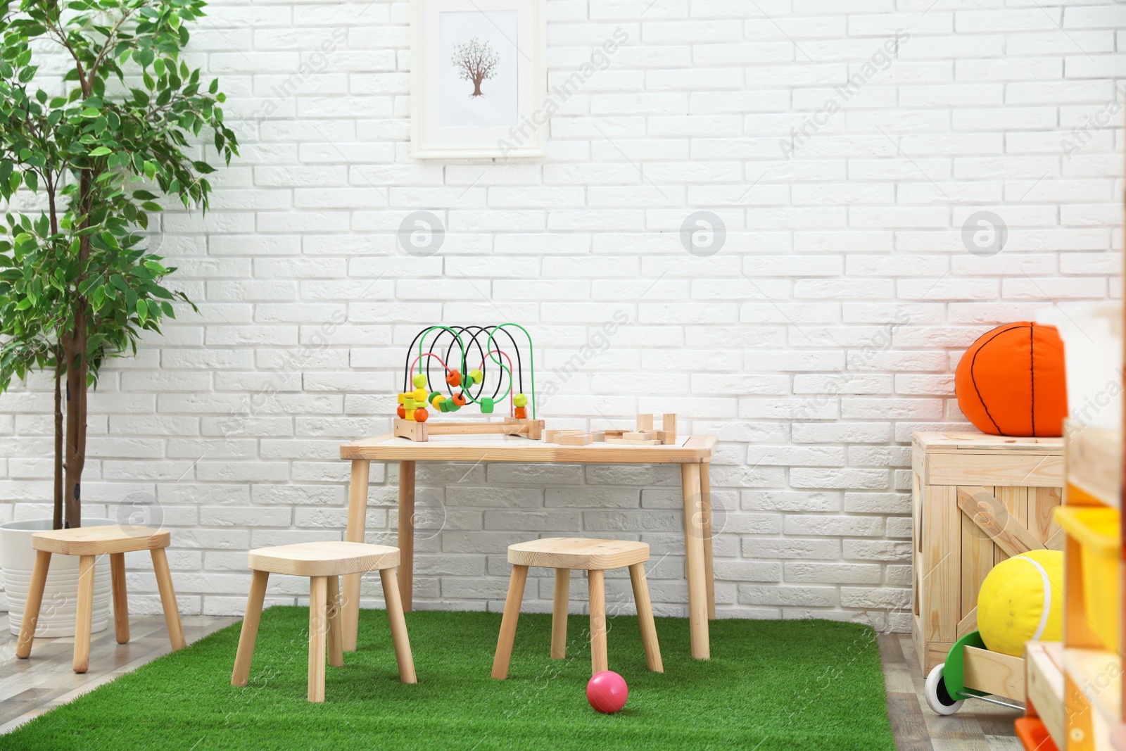 Photo of Stylish playroom interior with toys and modern wooden furniture