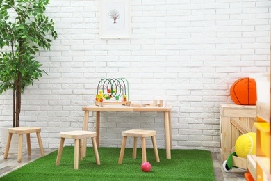 Stylish playroom interior with toys and modern wooden furniture