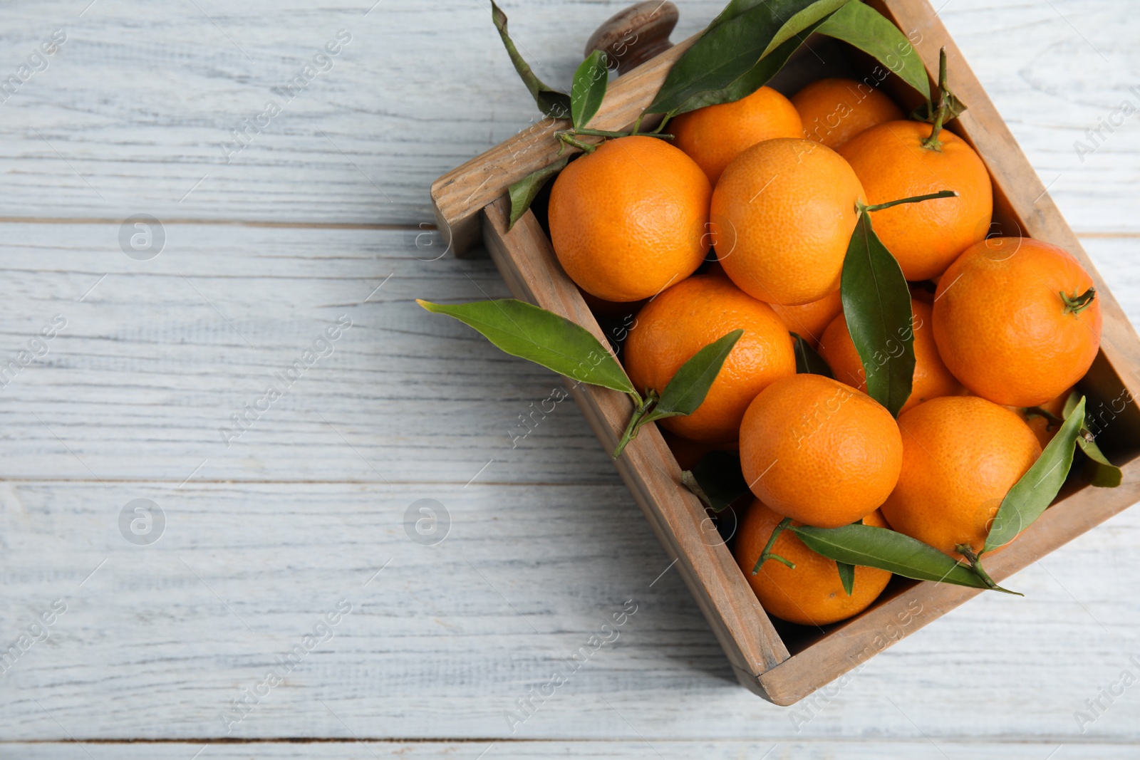 Photo of Crate with fresh ripe tangerines and space for text on wooden background, top view