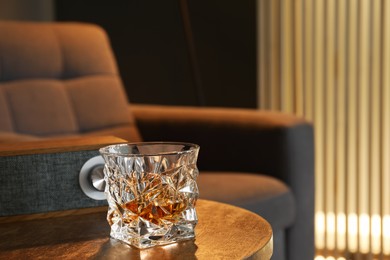 Photo of Glass of whiskey on table in room, space for text. Relax at home