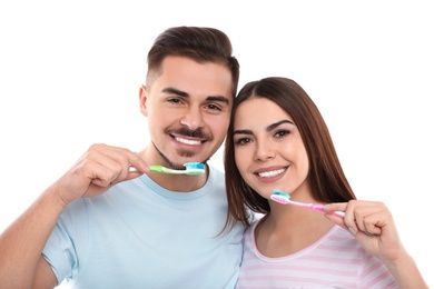 Photo of Happy couple brushing teeth on white background