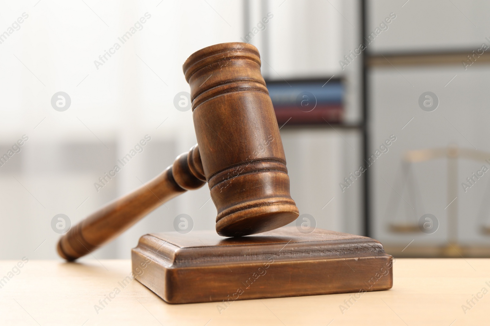 Photo of Wooden gavel and sound block on table indoors, closeup