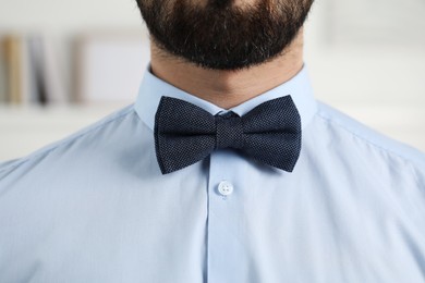 Photo of Man in shirt and bow tie indoors, closeup