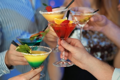 Group of young people holding martini cocktails at party, closeup