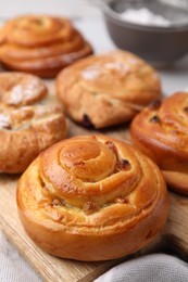 Delicious rolls with raisins on table, closeup. Sweet buns