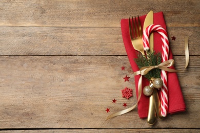 Photo of Cutlery set and festive decor on wooden table, flat lay with space for text. Christmas celebration