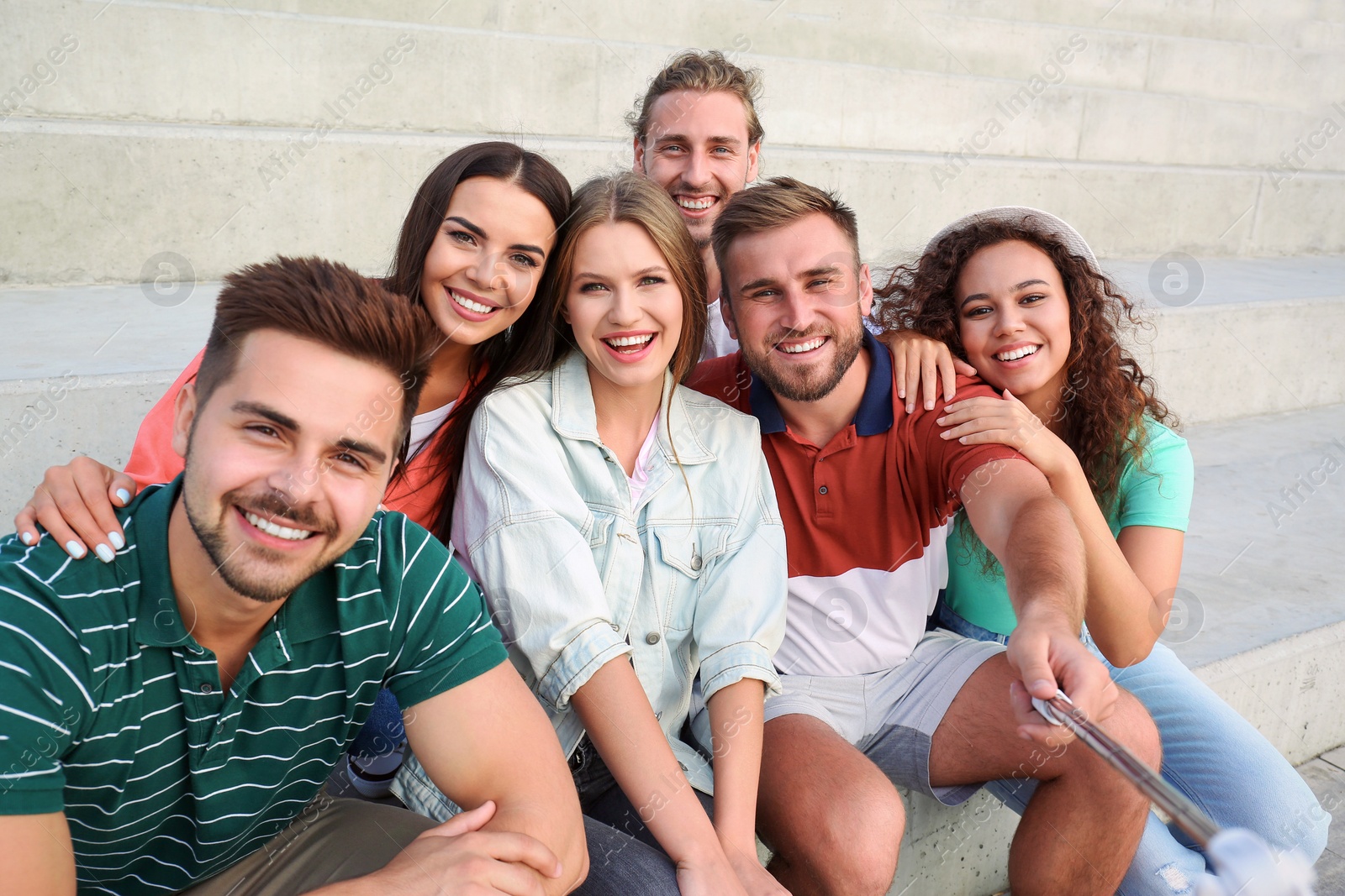 Photo of Happy young people taking selfie on stairs outdoors