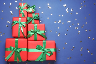 Christmas tree made with different gift boxes on blue background, flat lay. Space for text