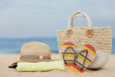 Photo of Bag and beach objects on sand near sea