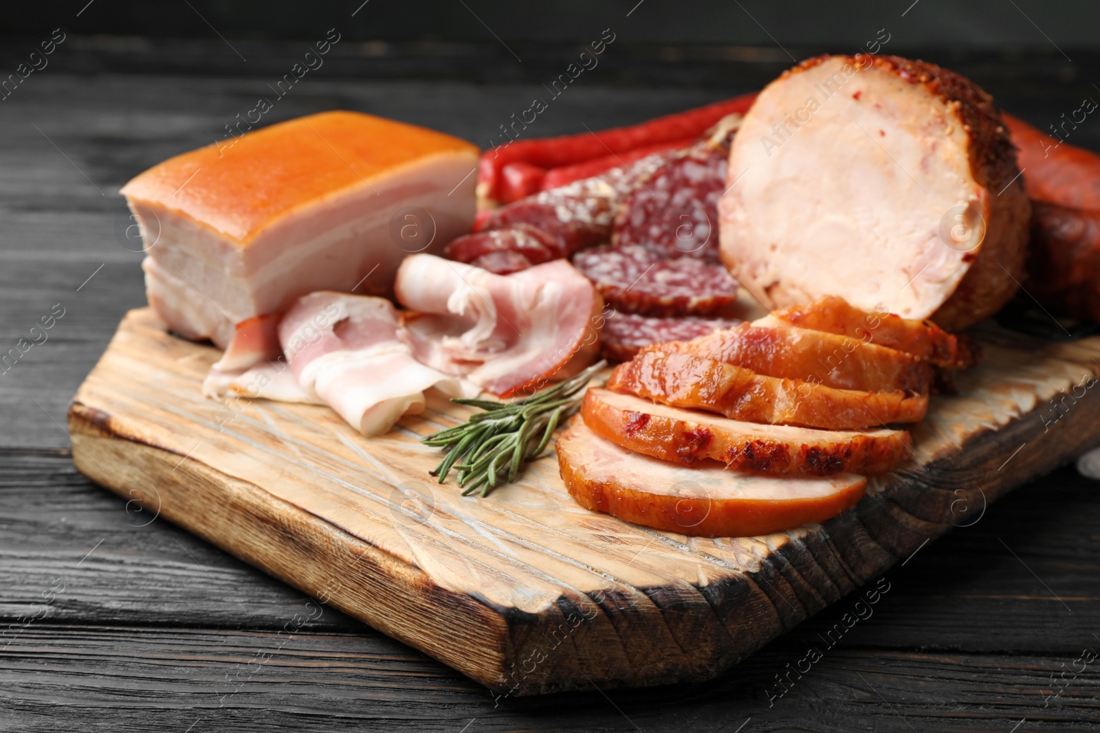 Photo of Cutting board with different sliced meat products served on table