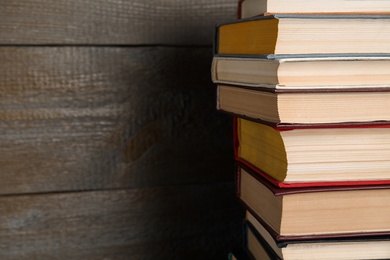 Stack of hardcover books on wooden background, closeup. Space for text