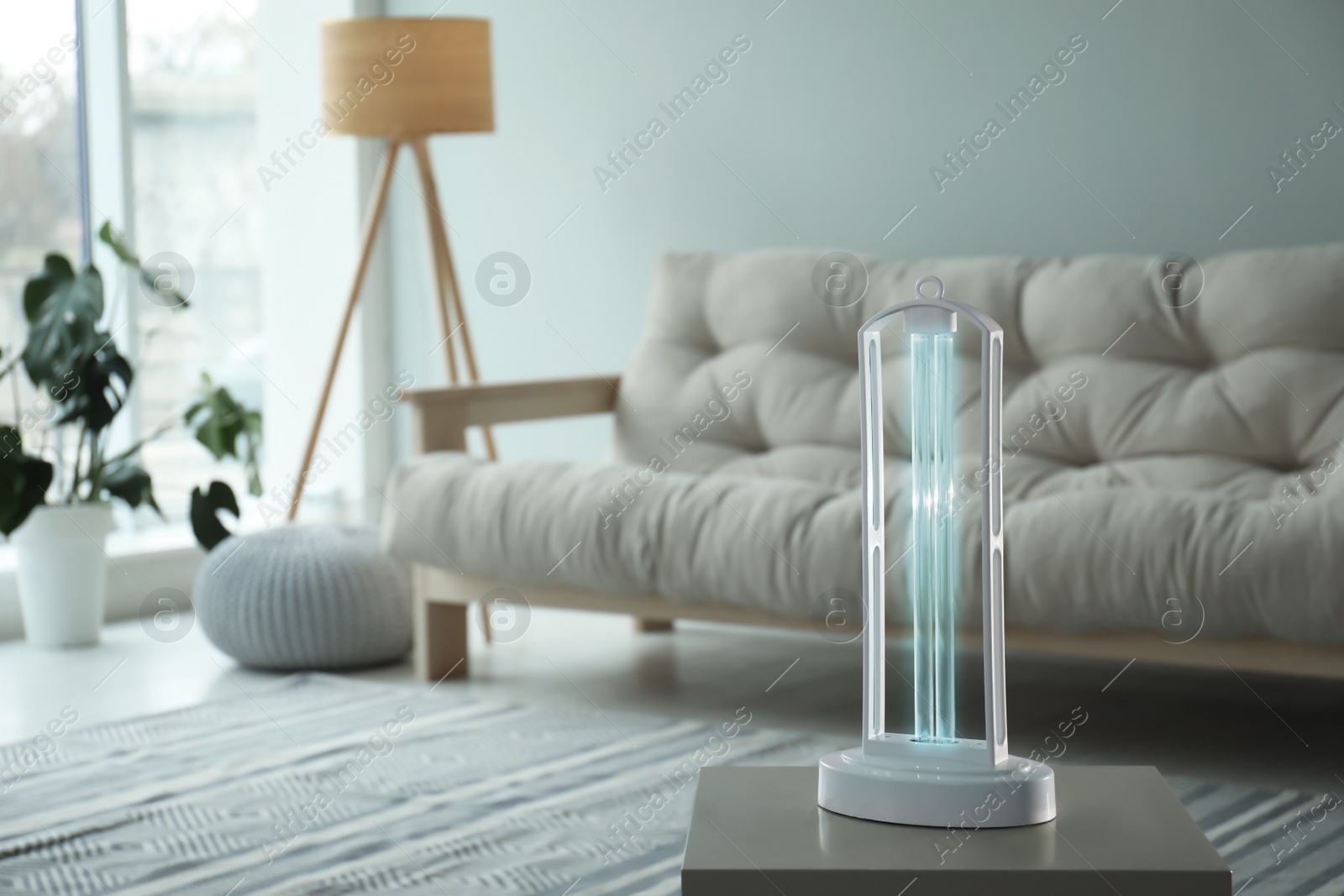 Photo of UV sterilizer lamp on table at home. Space for text