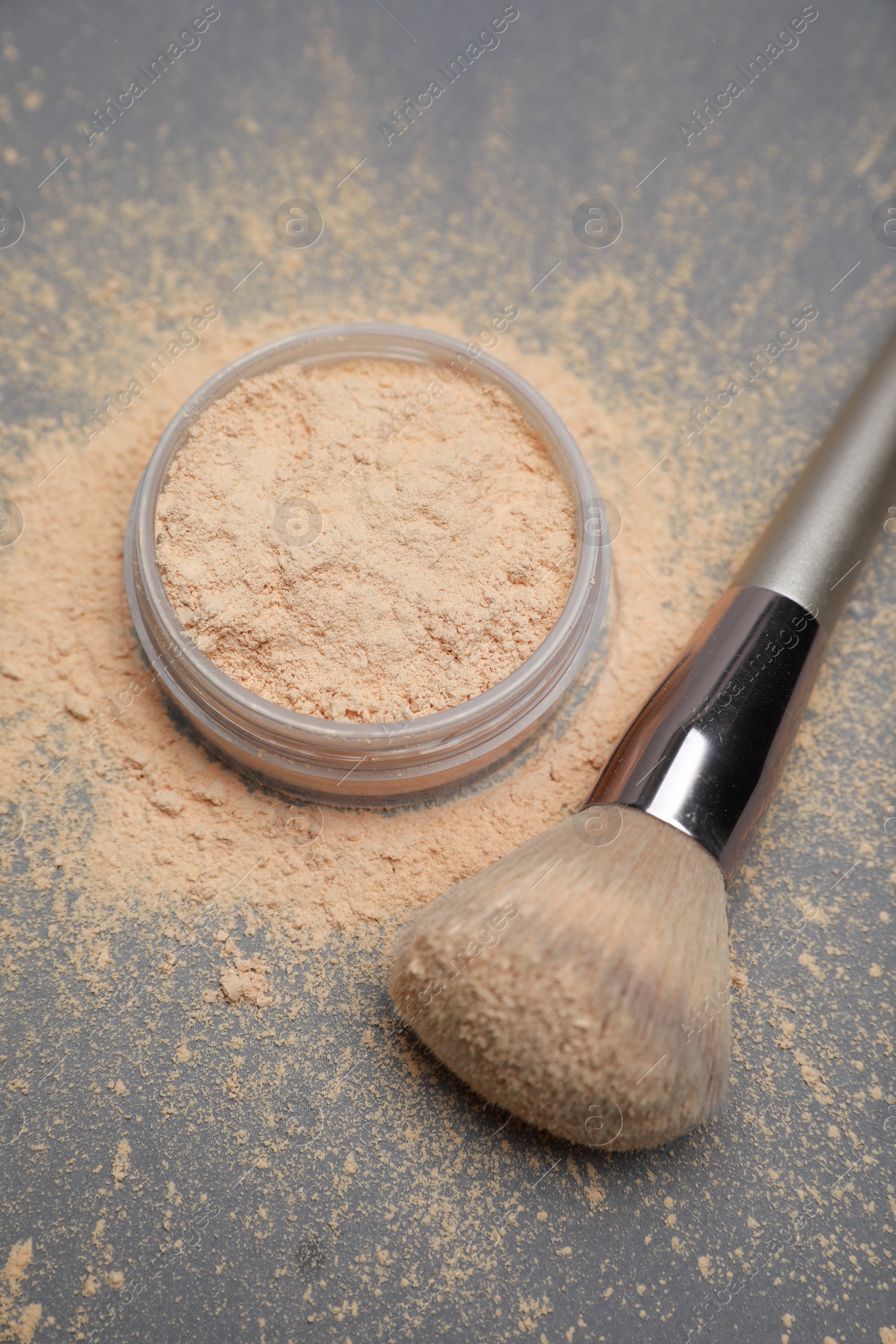 Photo of Loose face powder and makeup brush on grey background, above view