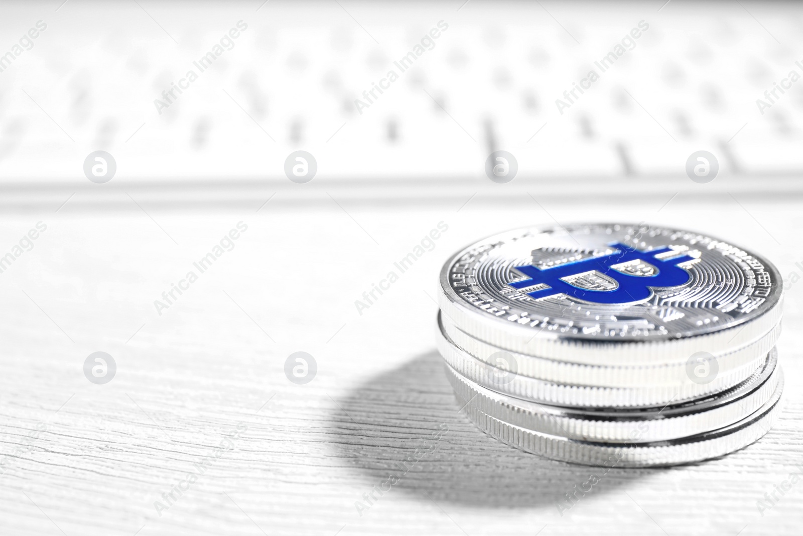 Photo of Silver bitcoins on wooden table, closeup. Space for text