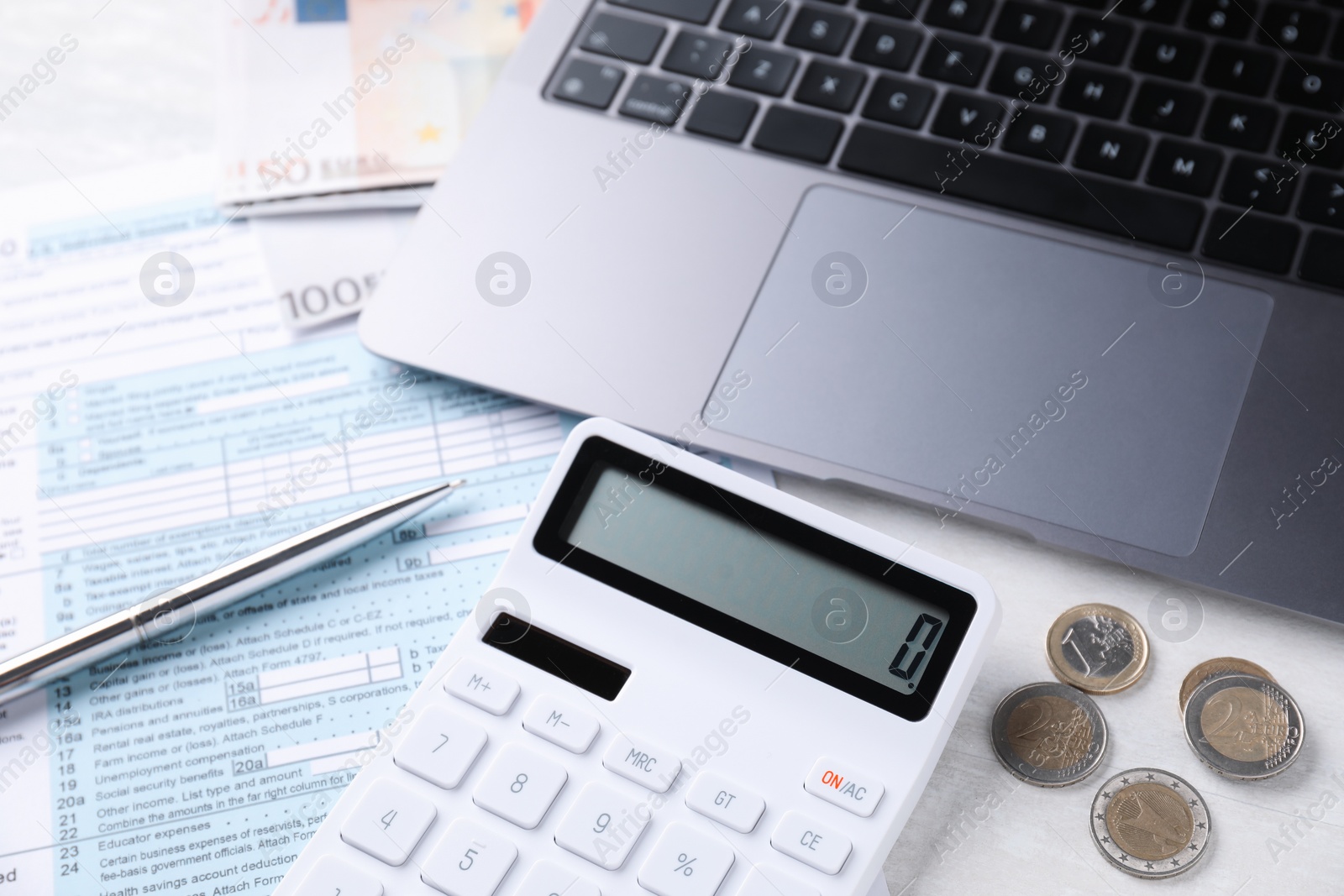 Photo of Tax accounting. Calculator, money, pen, document and laptop on light grey table