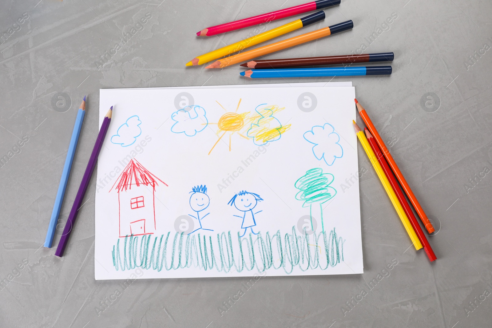 Photo of Cute child`s drawing and colorful pencils on grey textured table, flat lay