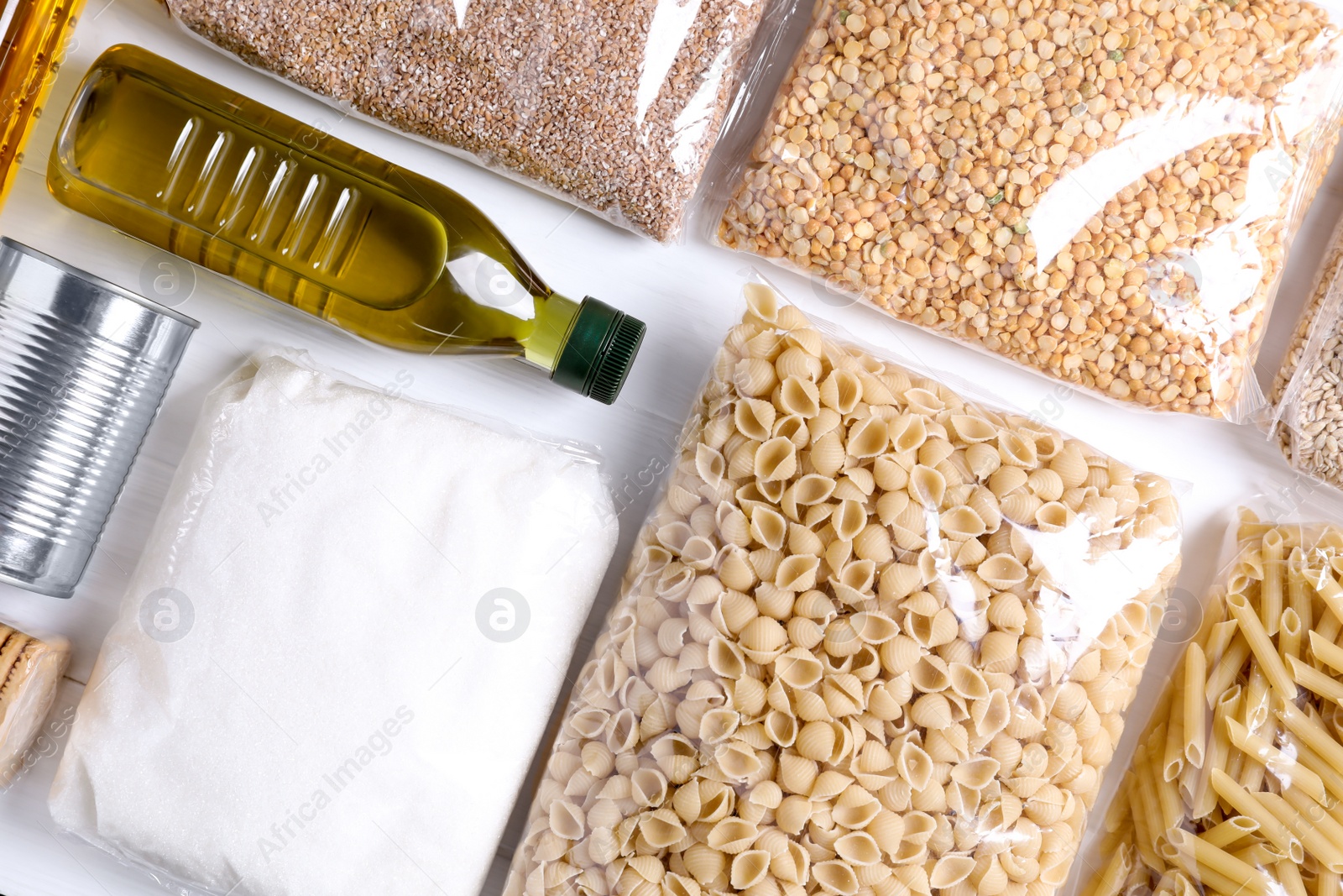 Photo of Different products on white wooden table, flat lay. Food donation