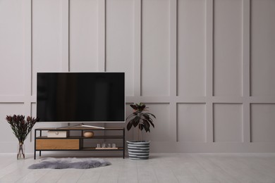 Photo of Stylish room interior with TV on wooden cabinet, space for text